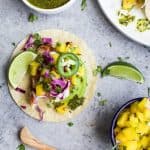 30 Minute GRILLED FISH TACOS topped with a fresh MANGO SALSA, Avocado, and Chimichurri! This easy grilling recipe is one "winner" of a meal that you're family will fall in love with! | gluten free recipes