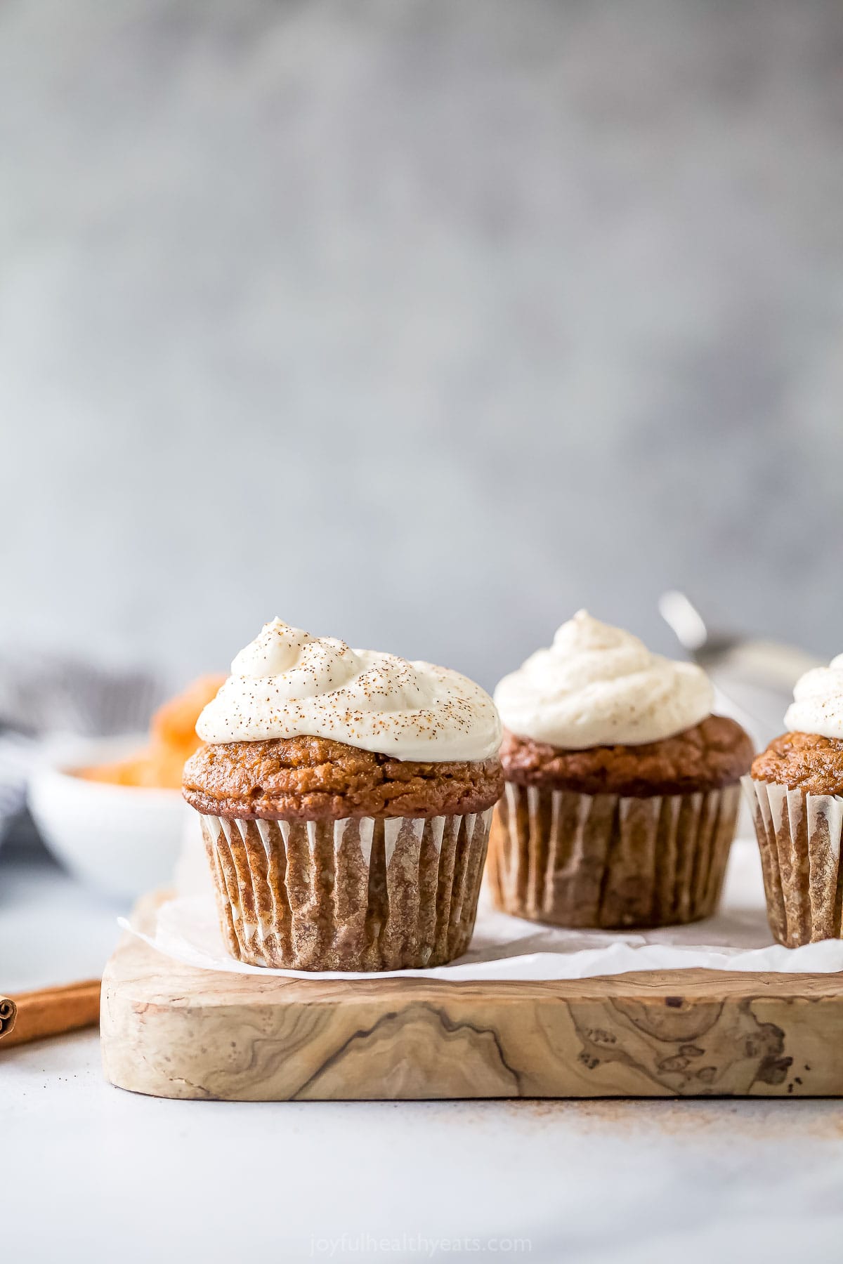 These pumpkin spice cupcakes with cinnamon and a healthy cream cheese frosting are the perfect 35-minute fall treat. Two pumpkin spice cupcakes.