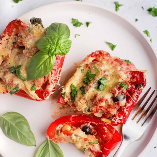 Southwestern ground turkey stuffed peppers on a white plate with a fork and some baby spinach