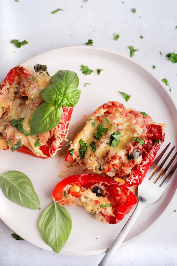 Southwestern ground turkey stuffed peppers on a white plate with a fork and some baby spinach