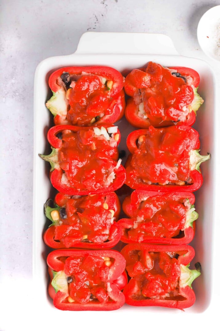 Eight stuffed pepper halves topped with fire roasted tomatoes