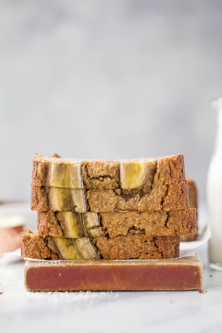 Four Slices of Paleo Banana Bread Stacked Up on a Cutting Board