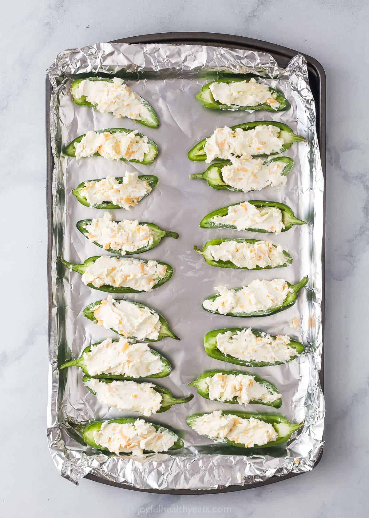 Adding the cheese filling to the jalapenos. 