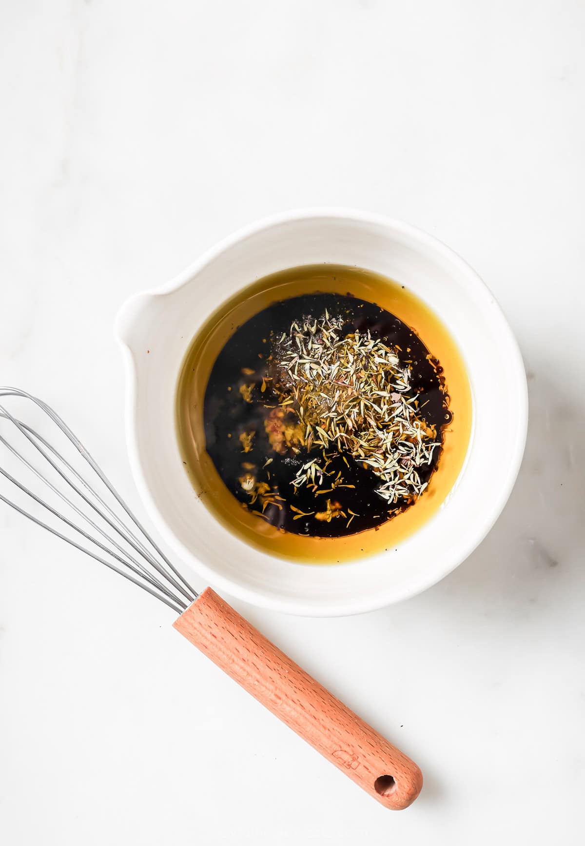 This recipe for balsamic vinaigrette is easy to whip up and the sweet, tangy flavor brings out the best in any salad—and so much more! Overhead view of ingredients for balsamic vinaigrette in bowl before whisking