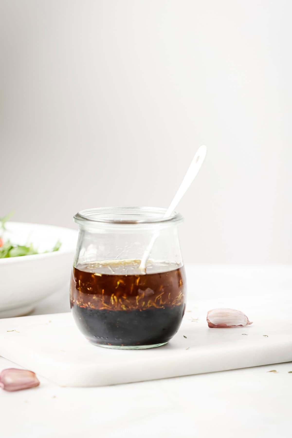 This recipe for balsamic vinaigrette is easy to whip up and the sweet, tangy flavor brings out the best in any salad—and so much more! Jar of homemade balsamic vinaigrette with spoon