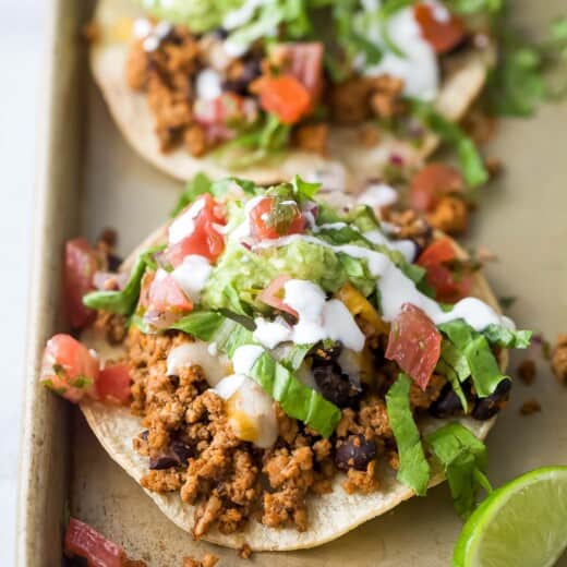 Close-up of a turkey-bean tostada with toppings.