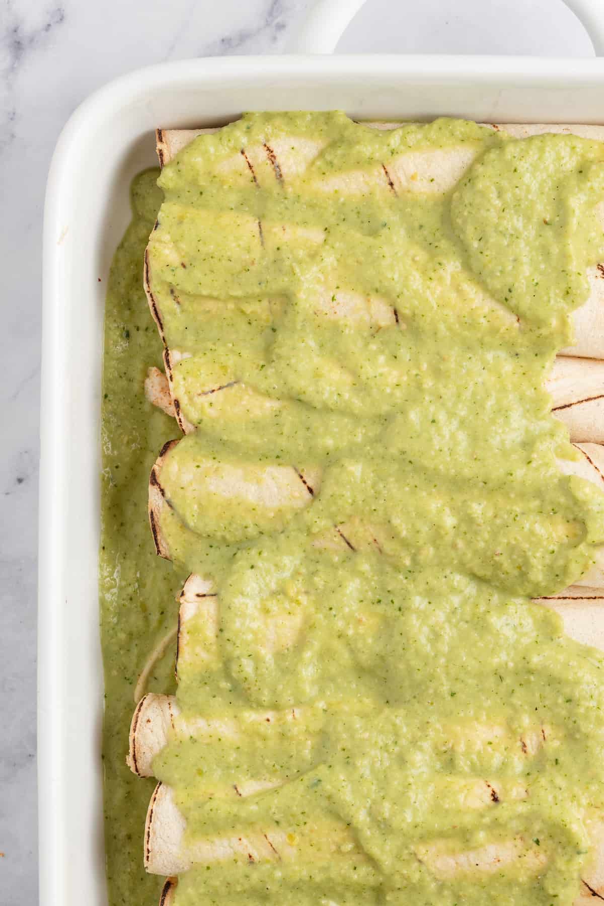 creamy verde sauce poured over wrapped tortillas