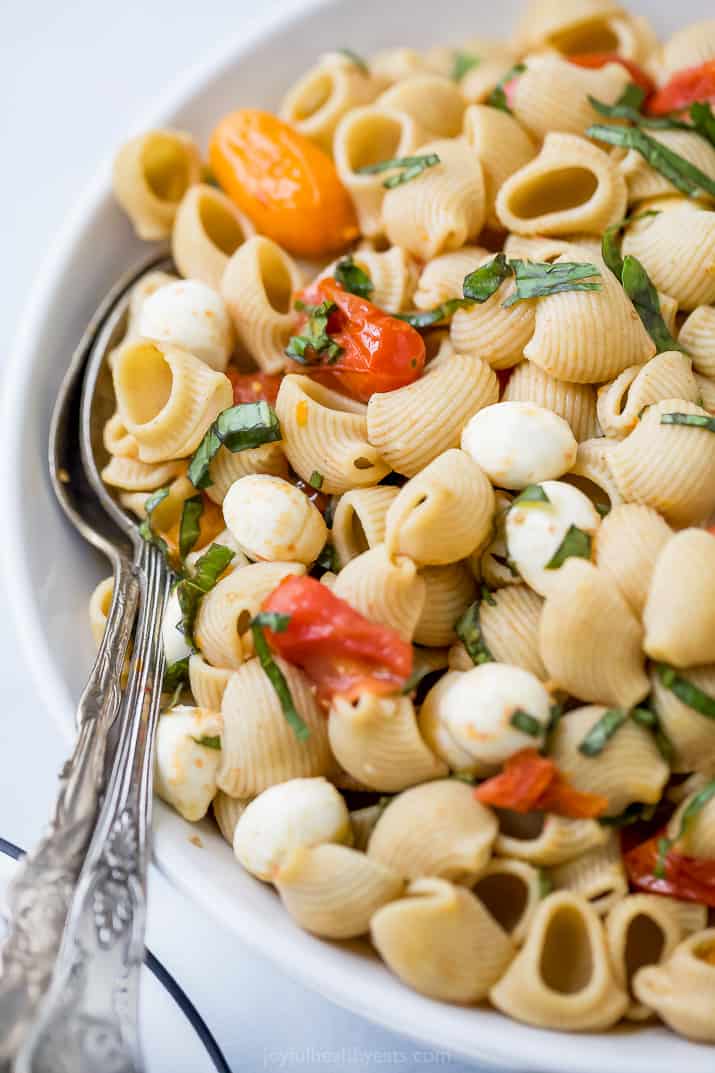 roasted tomato caprese pasta salad in a bowl with a spoon