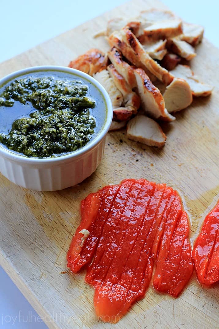 Toppings for Grilled Chicken Pesto Pizza on a cutting board