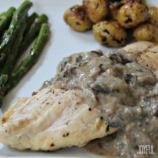 A Plate of Chicken with Creamy Mushroom Sauce and Veggies on the Side