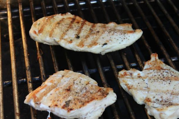 Three Boneless Chicken Breasts Cooking on the Grill