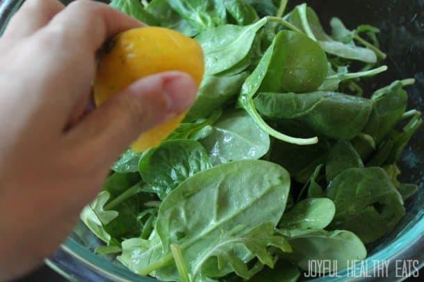 Image of Squeezing Lemon over Spinach & Arugula