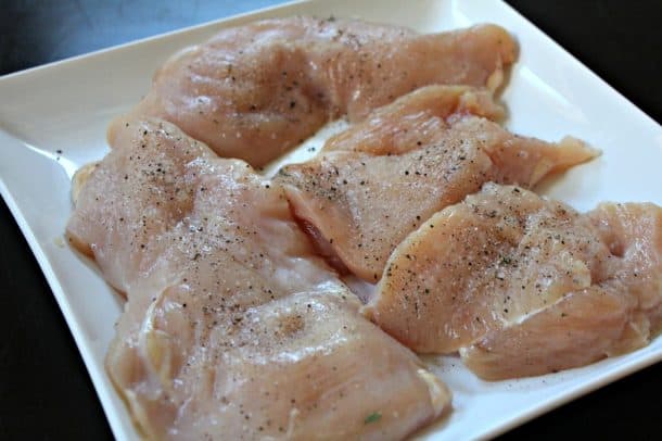Raw Chicken Breasts Seasoned with Salt and Pepper on a Plate