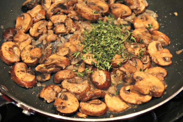 Mushrooms Cooking in a Pan with Thyme, Salt and Pepper
