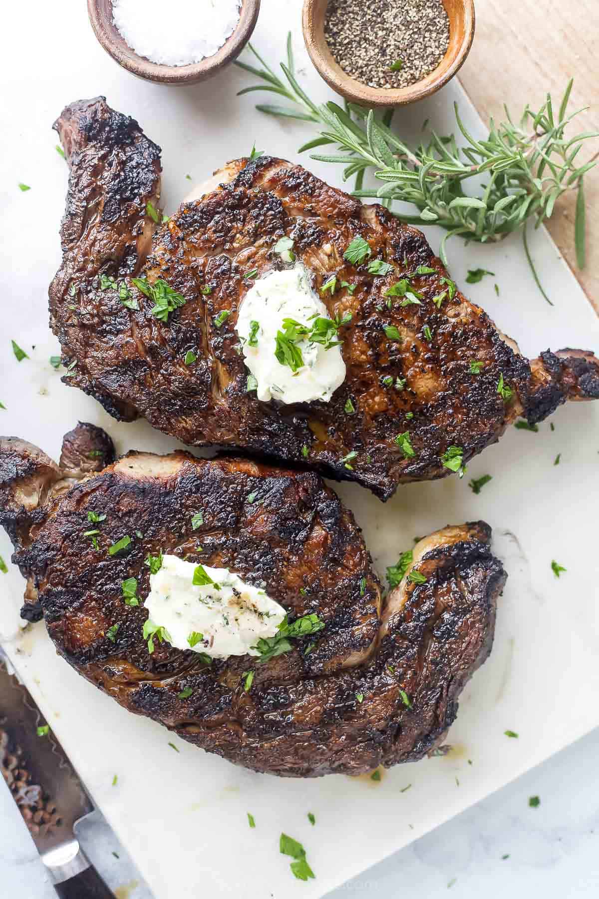 Two grilled steaks next to each other.