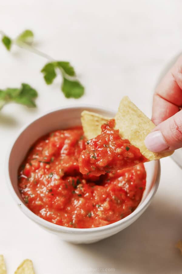 Dipping a chip into the homemade salsa.