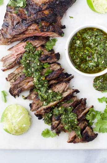 Skirt steak that's been partially sliced topped with chimichurri sauce