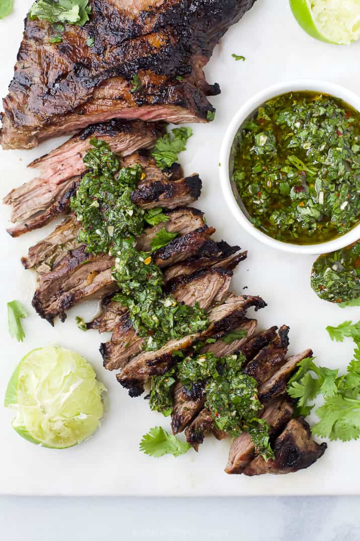 Skirt steak that's been partially sliced topped with chimichurri sauce