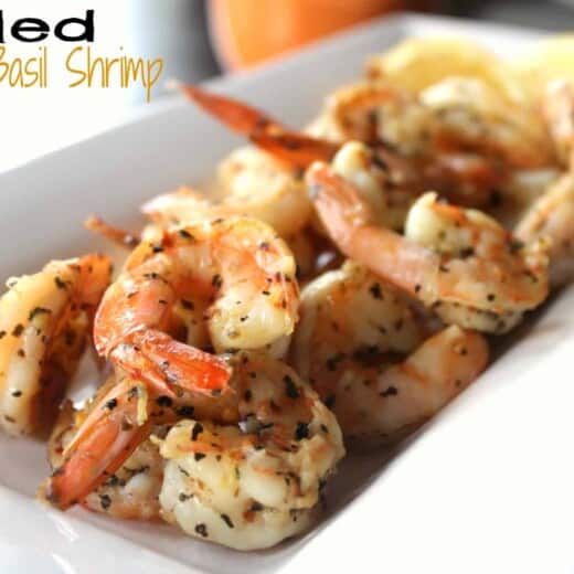 Grilled Garlic Basil Shrimp on a White Serving Plate with Lemon Slices