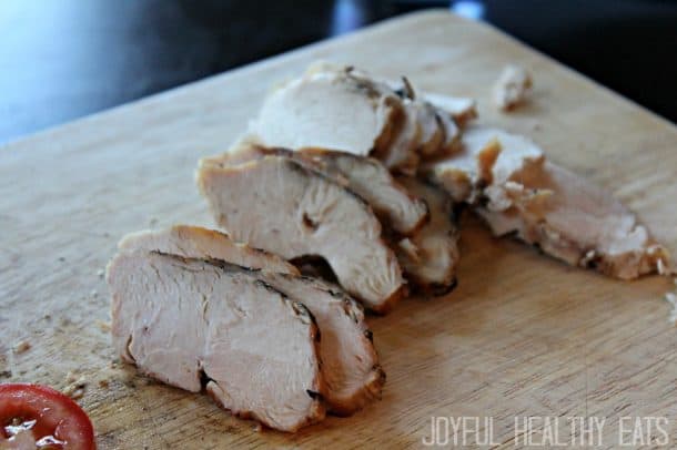 Sliced grilled chicken on a wooden cutting board