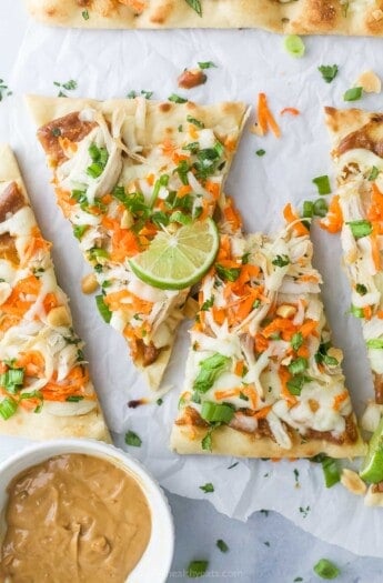 Sliced Thai chicken pizza with fresh cilantro on top.