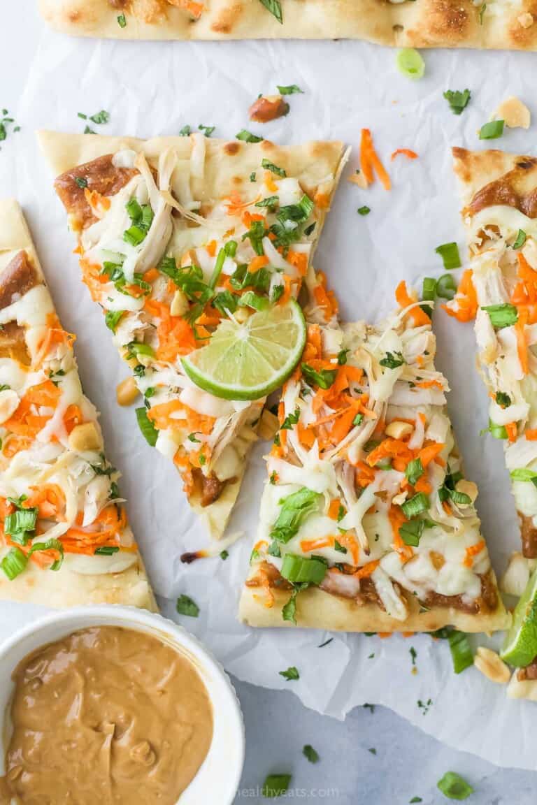Sliced Thai chicken pizza with fresh cilantro on top.