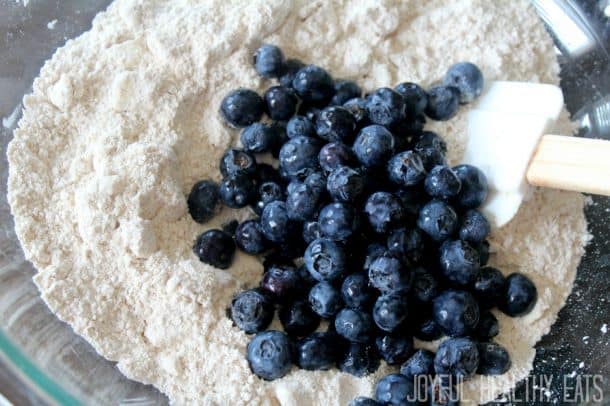 Dry ingredients and fresh blueberries in a mixing bowl