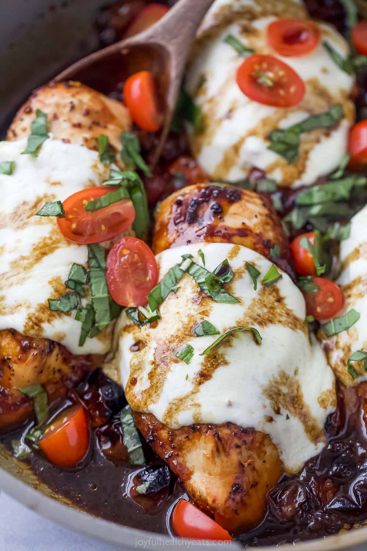 Close-up of chicken caprese with tomatoes, basil, and cheese. 