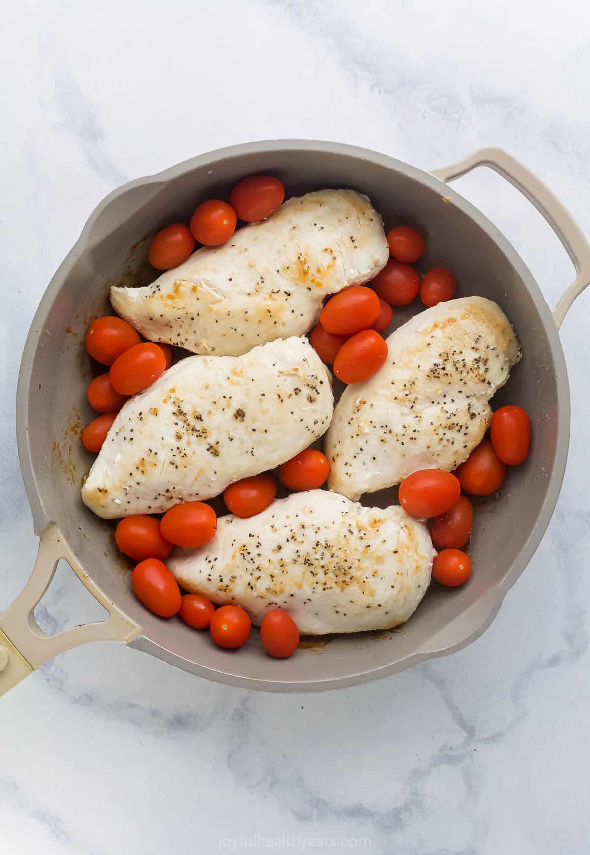 Chicken and tomatoes in the skillet. 