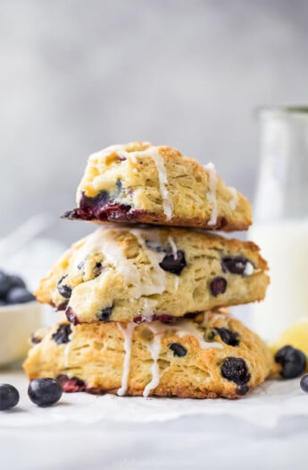 Stack of lemon blueberry scones with lemon glaze.