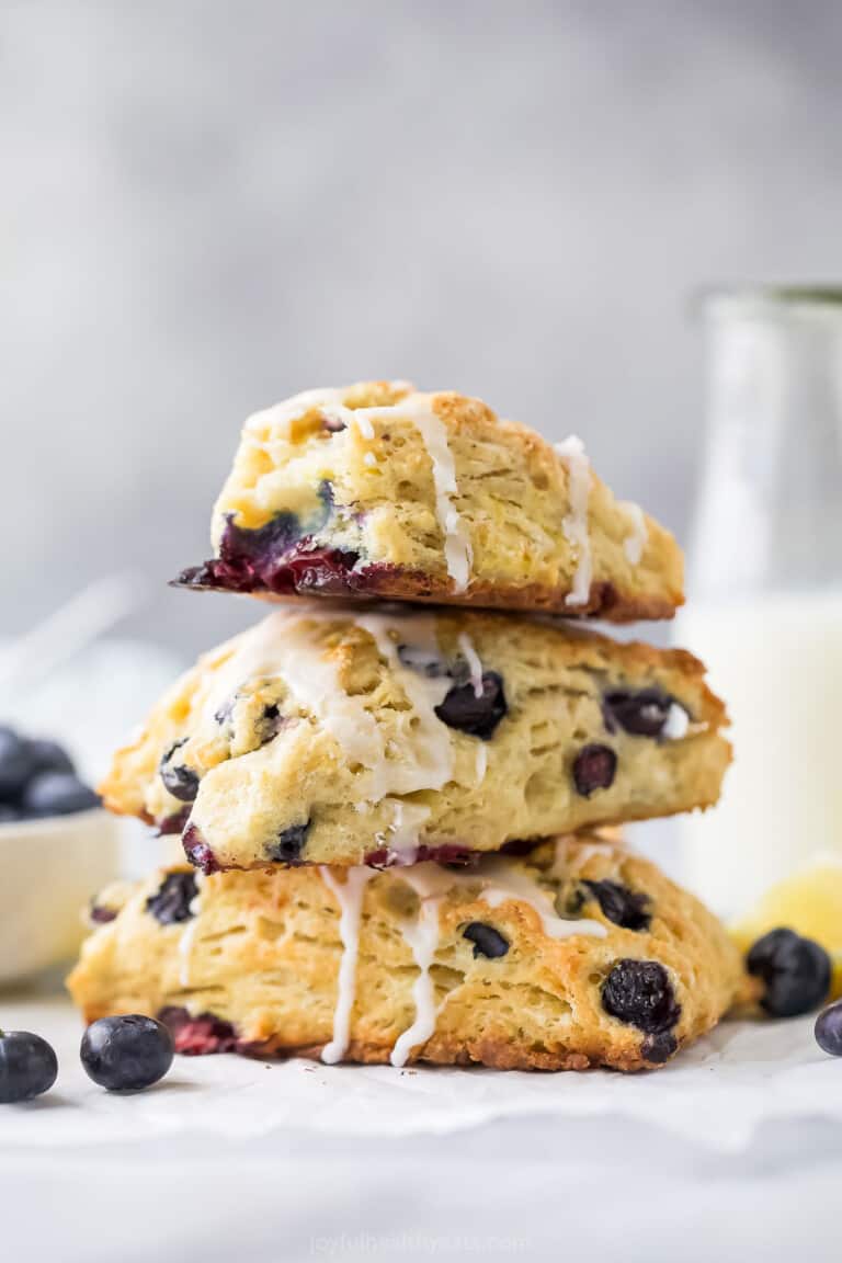 Stack of lemon blueberry scones with lemon glaze.