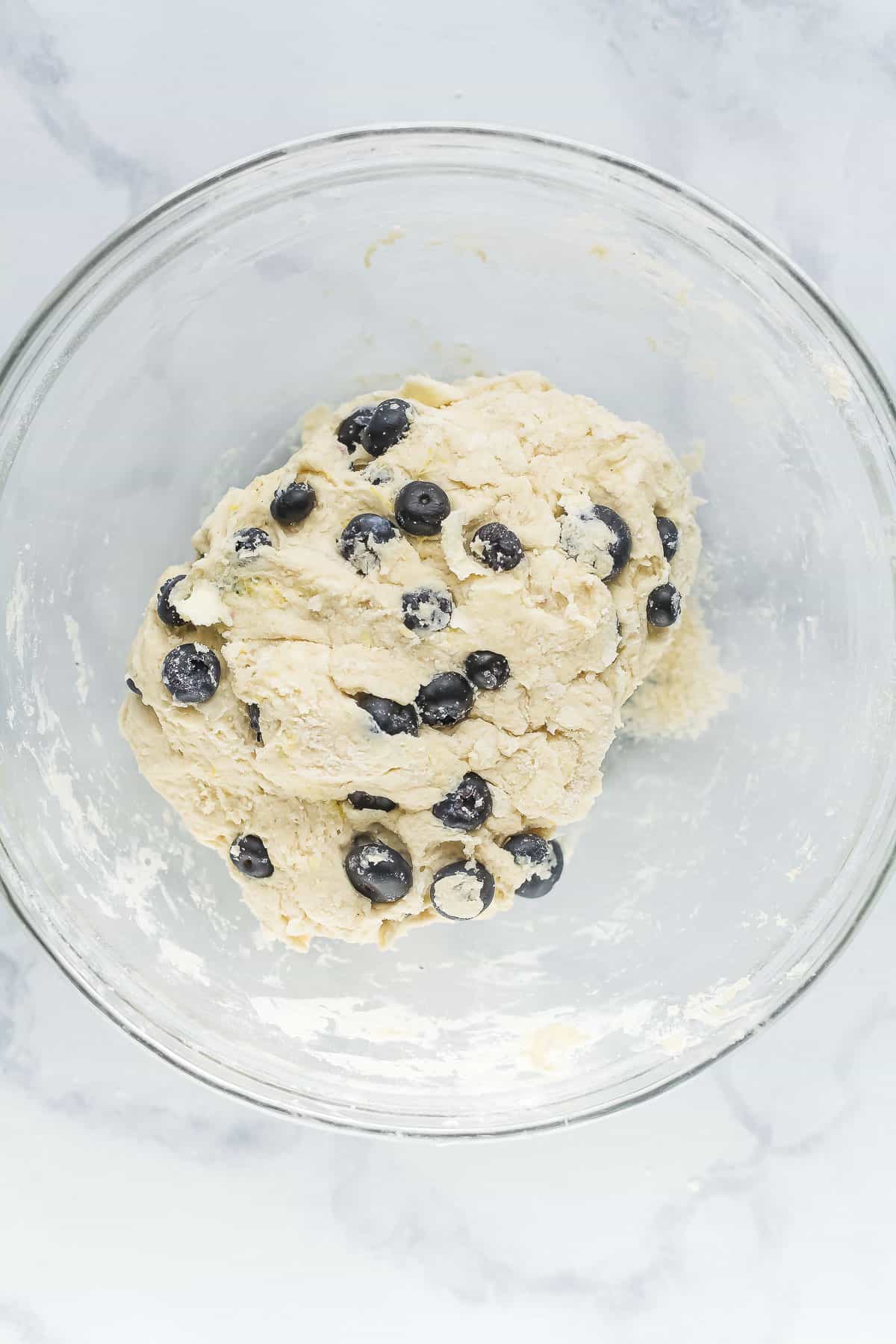 Adding the blueberries to the dough. 