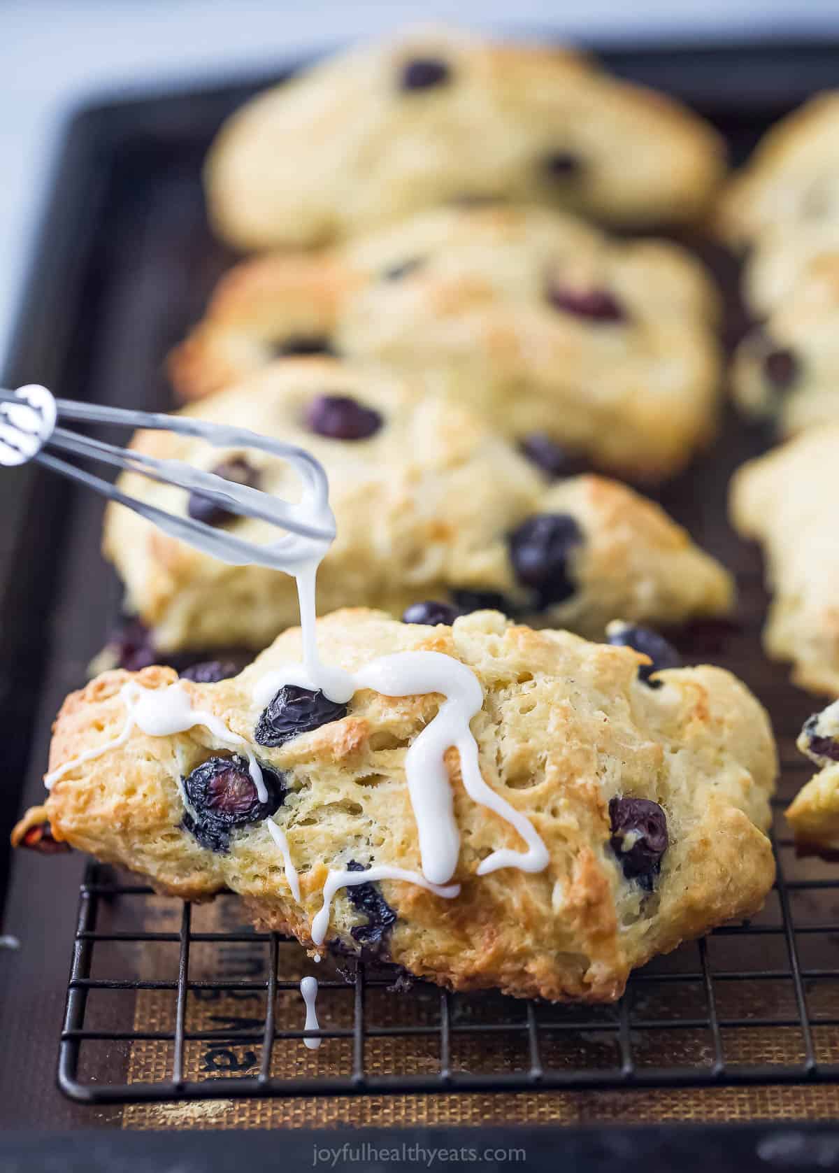 Drizzling the glaze over the scones. 