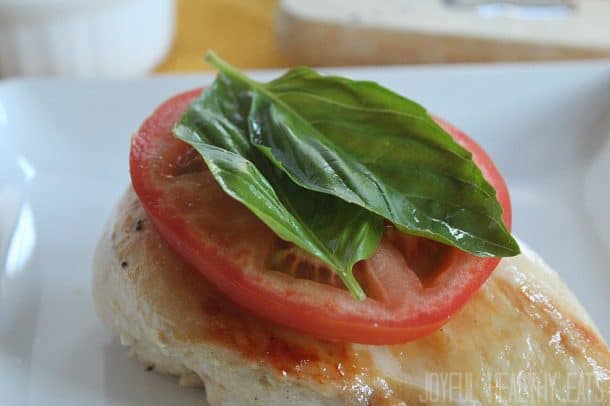 Chicken breast with sliced tomato and fresh basil