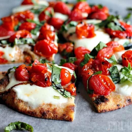 Six Slices of Caprese Flatbread on a Piece of Wax Paper