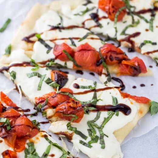 Caprese flatbread with mozzarella, tomatoes, basil, and balsamic reduction.