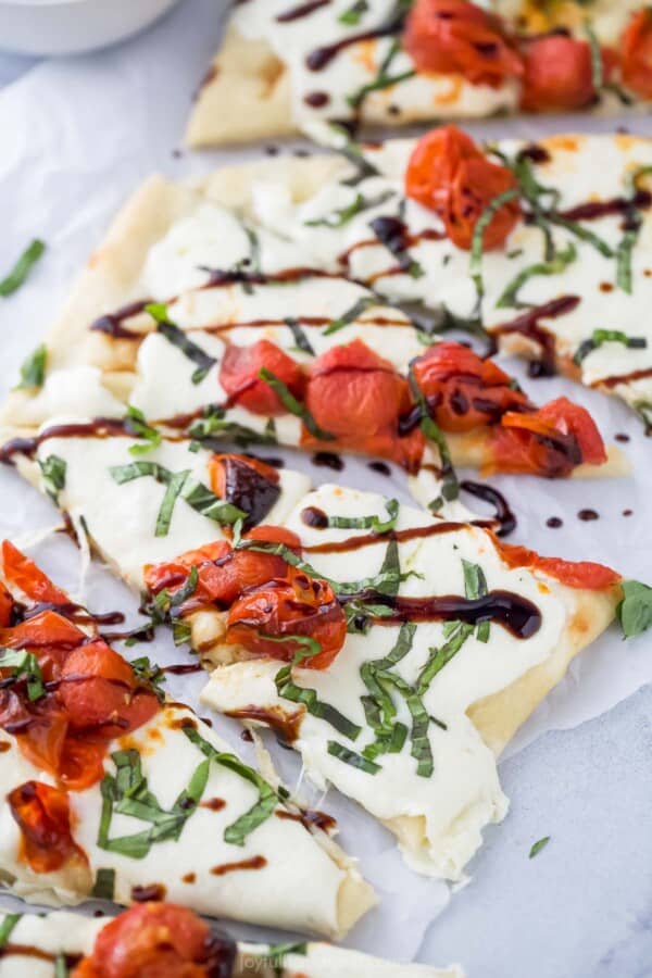 Caprese flatbread with mozzarella, tomatoes, basil, and balsamic reduction.