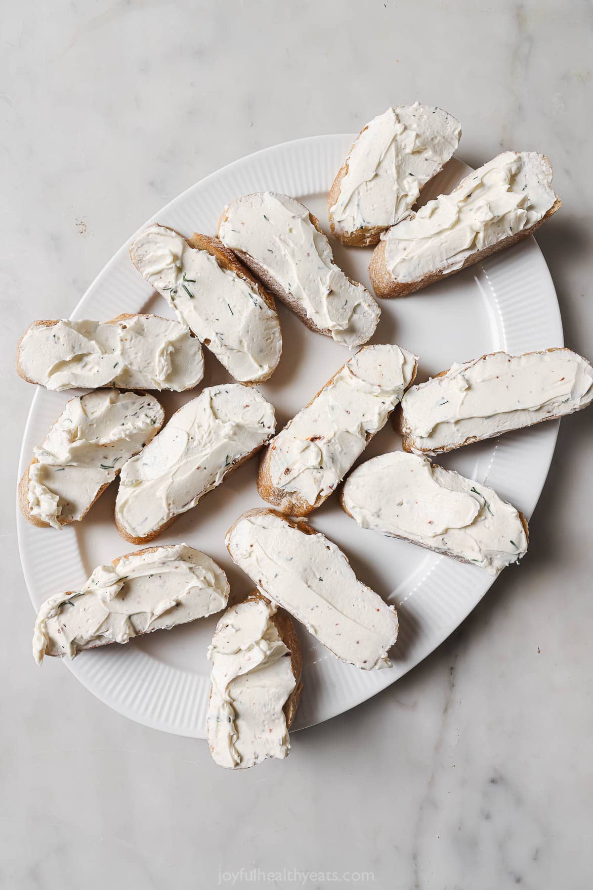 Spreading the cream cheese mixture over the bread slices. 