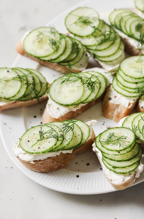 Cucumber sandwiches with a smooth cream cheese-dill mixture on top.
