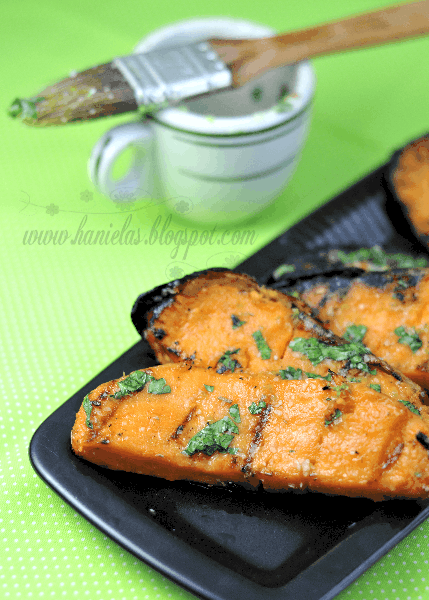 Slices of grilled sweet potatoes on a black plate