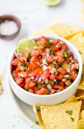 close up of easy homemade pico de gallo recipe in a bowl with chips around it