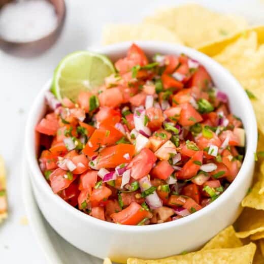 close up of easy homemade pico de gallo recipe in a bowl with chips around it