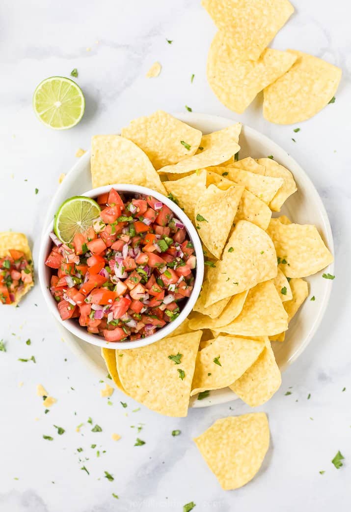 homemade pico de gallo in a bowl with chips surrounding it