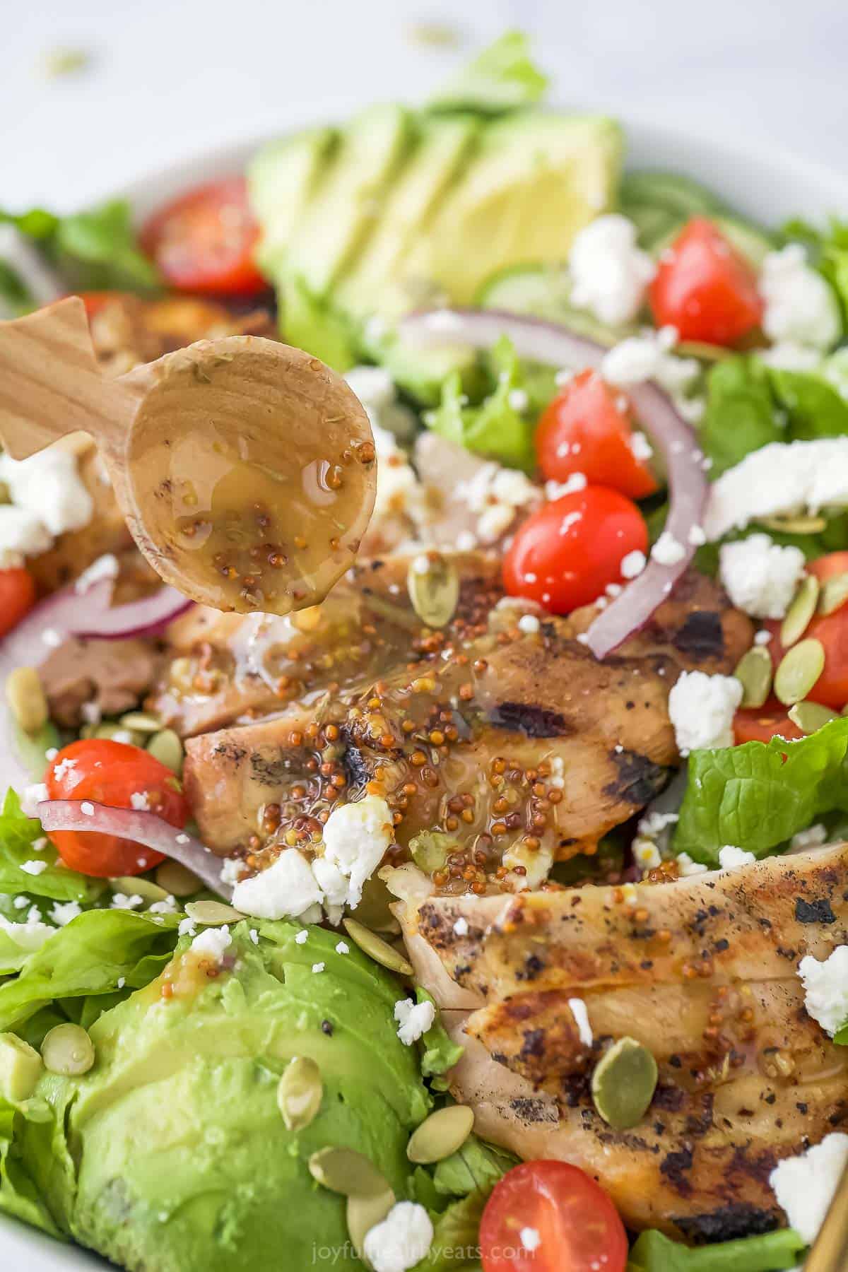 Pouring dressing over the salad.