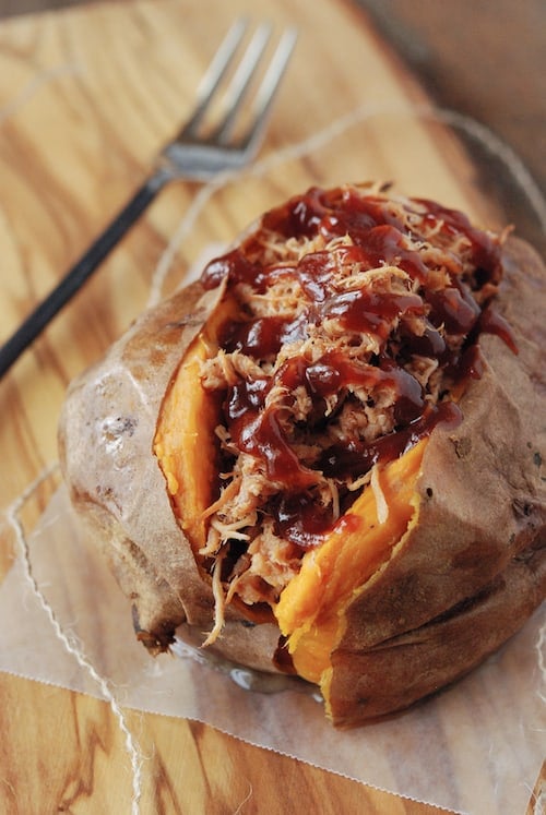 Top view of a roasted sweet potato topped with pulled pork