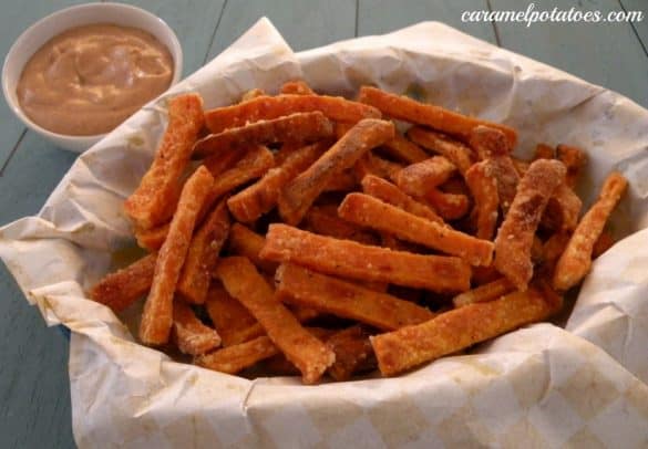 Sweet potato fries in a paper-lined basket with dipping sauce