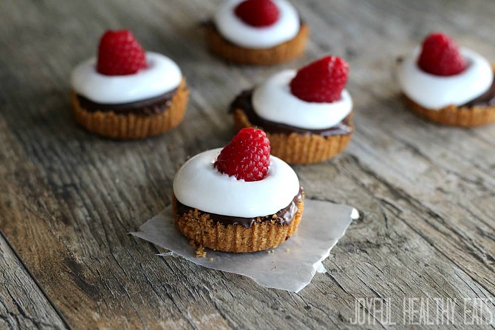A twist on the every popular S'more! Mini S'mores Cups topped with fresh raspberries in honor of National S'mores Day. They are the perfect bite size dessert!