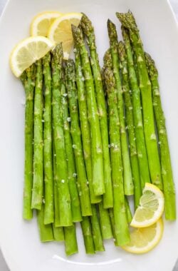 Roasted asparagus on platter with lemon slices