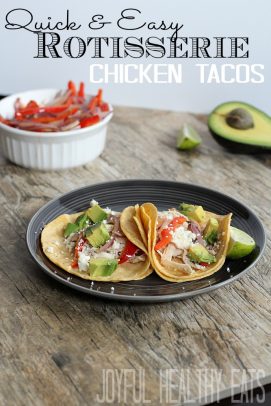 Shredded Chicken Tacos on a black plate and surrounded by fresh ingredients