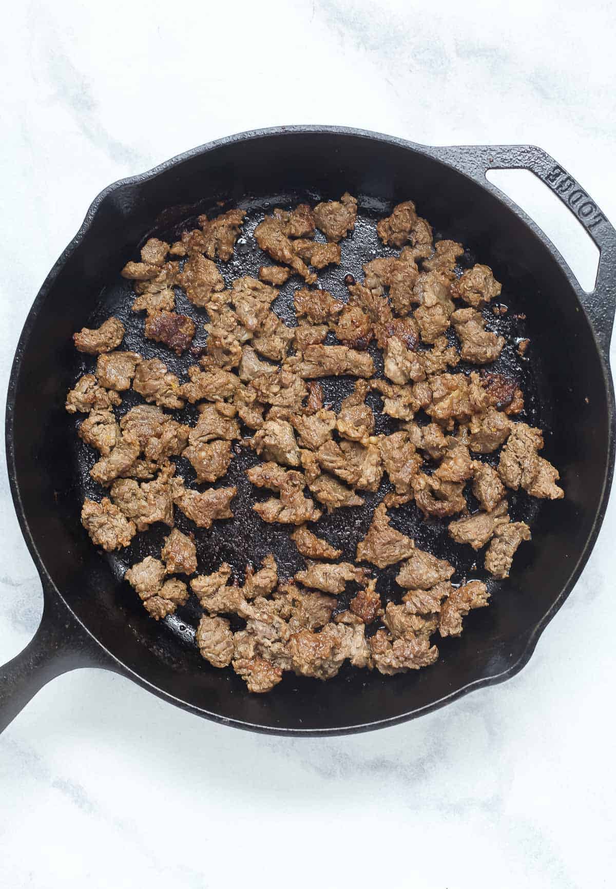 Searing the steak in the skillet. 